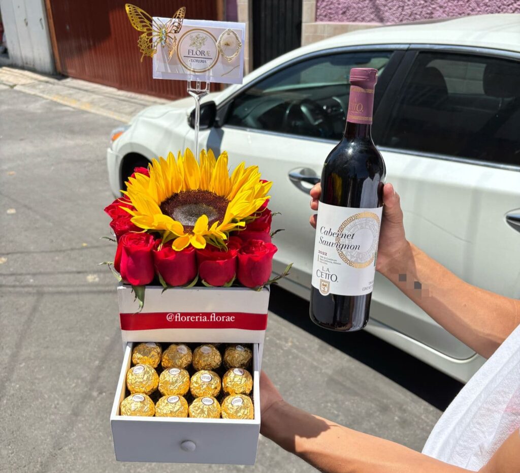 alajero de madera con rosas girasol chocolates y vino