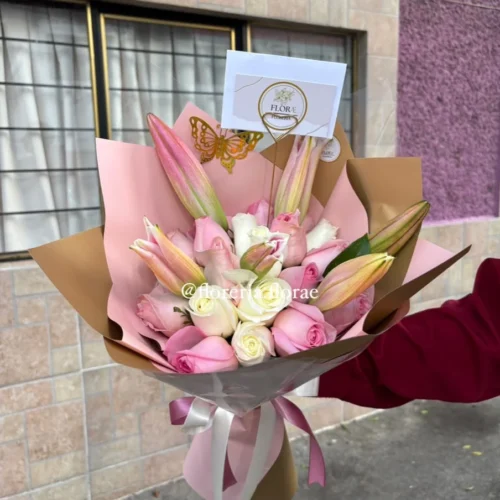 Arreglo de rosas blancas y rosadas con lirios en envoltura elegante de Florería Florae.