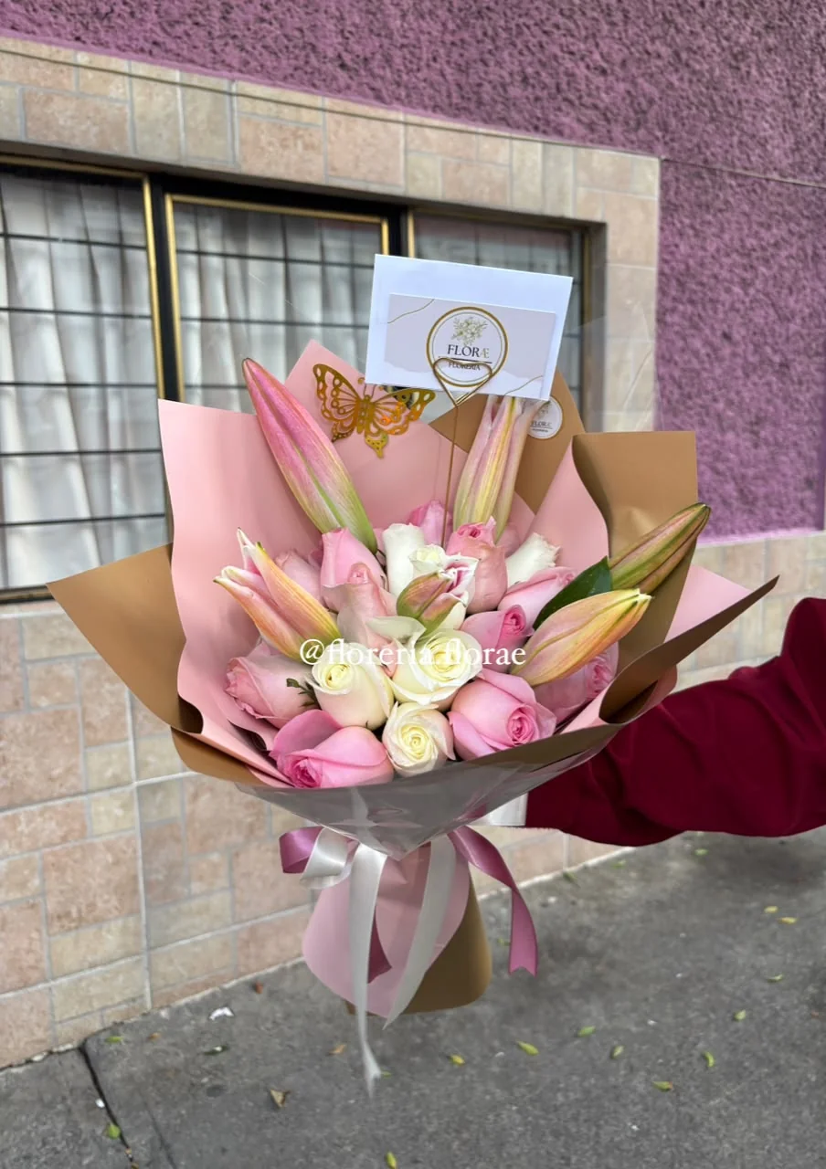 Arreglo de rosas blancas y rosadas con lirios en envoltura elegante de Florería Florae.