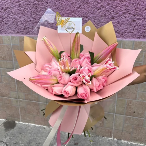 Ramo de rosas rosadas y lirios con envoltura rosa y dorada de Florería Florae.