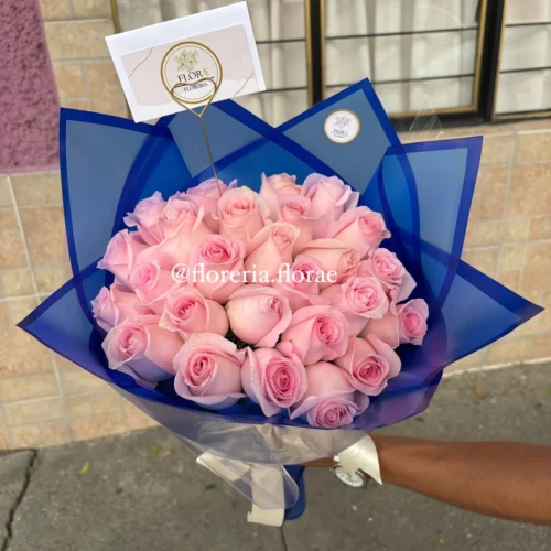 Bouquet de rosas rosadas envuelto en papel azul elegante, regalo romántico moderno de Florería Florae.