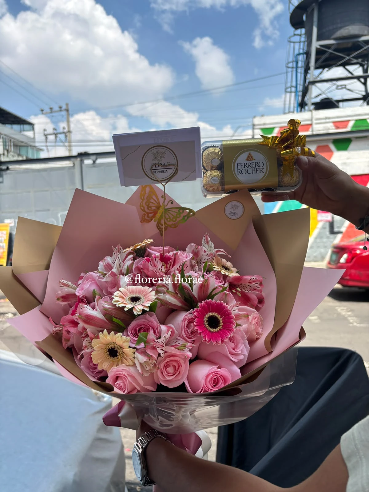 Ramo de 24 rosas rosas con mini gerberas, astromelias, mariposa de fantasía y caja de chocolates Ferrero Rocher.